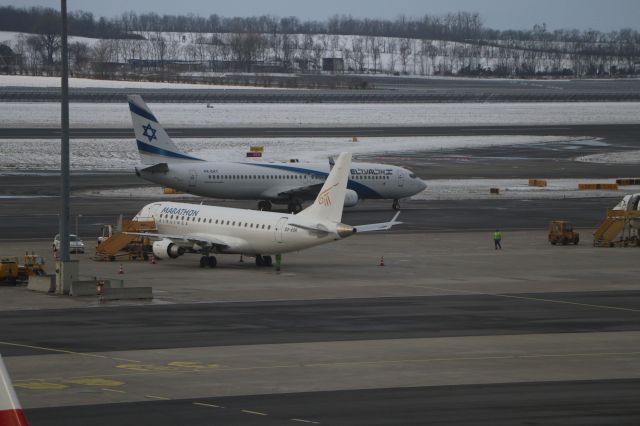 Embraer ERJ-145 (SX-ASK) - 12/7/23 El-Al 4X-EKT taxis in past Marathon-Chronos on a hard stand