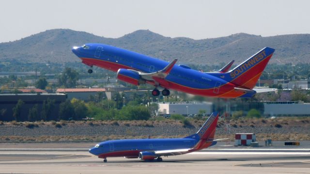 Boeing 737-700 (N242WN) - A Southwest 737 taking off over another company 737.