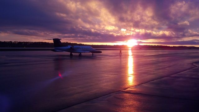 Learjet 35 (C-GAJS) - Sunset on the Port City Air FBO ramp, Aircraft being marshaled for engine start and taxi out. 06/18/13