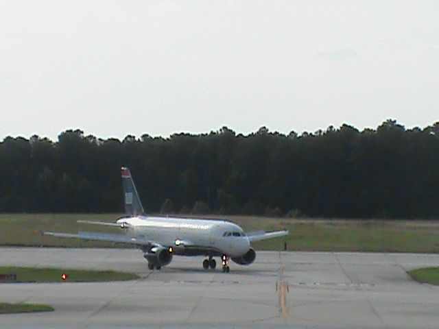 Airbus A319 (N705UW) - US Airways Flight 1915 From KCLT is taxiing down the road after landing 5L at KRDU. Taken 6/20/2013.