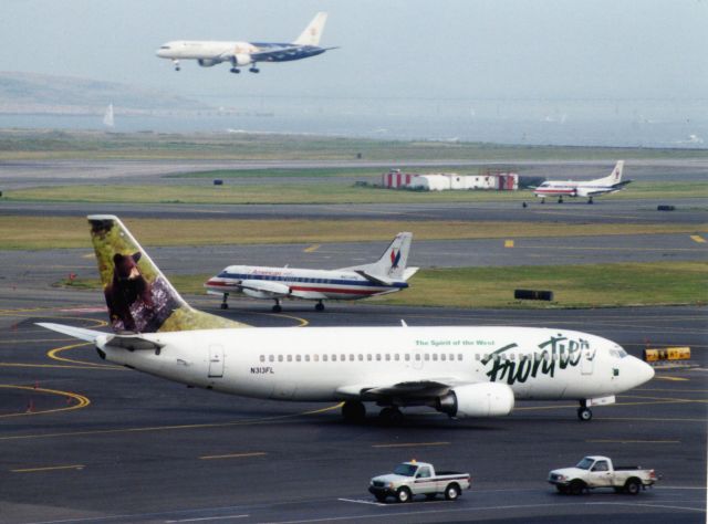 BOEING 737-300 (N313FL) - Frontier B737-300 (N313FL) arrives at Logan in August 2001 with 2 American Eagle Saabs preparing to depart and Delta B757-200 in Special Olympic Scheme arriving on 4R.