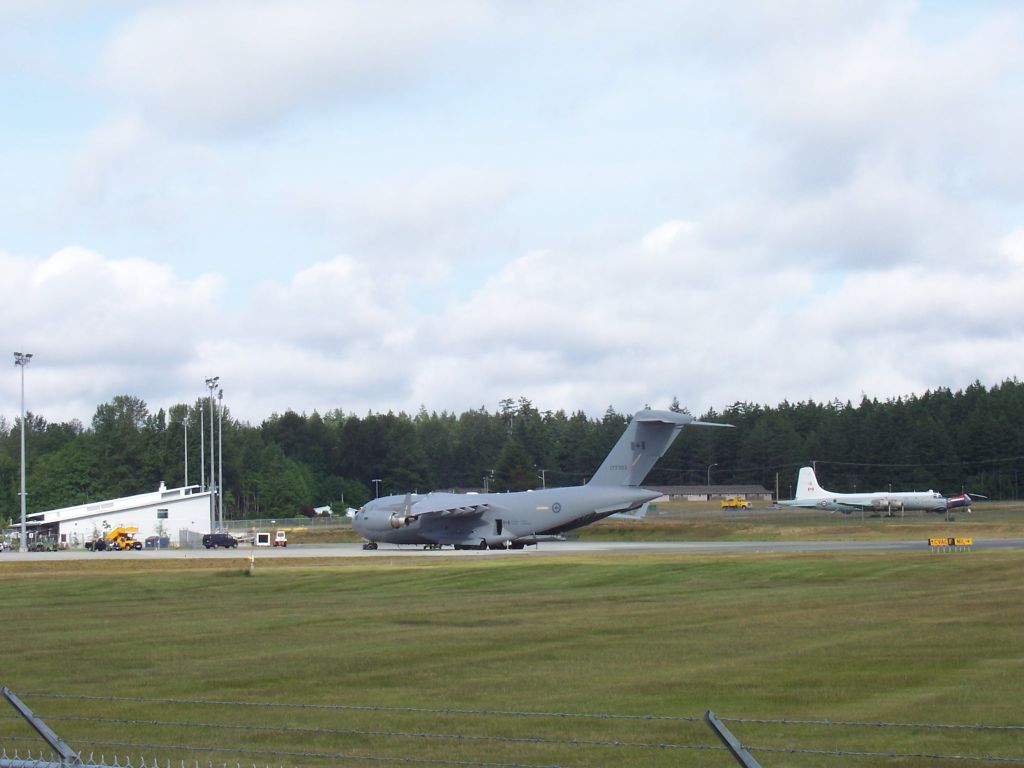 Boeing Globemaster III (17-7703) - CC117 Globemaster III one of 4 Canadian heavy lift aircraft  of this type parked ajacent to our Comox Valley passenger terminal    Older tourbo prop Aurora  and flying banana in the outdoor airpark, air museum  in the back-ground