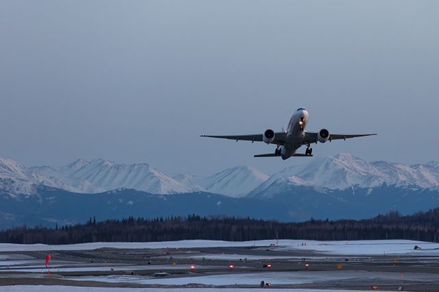 Boeing 777-200 (N885FD) - Taking off from Rwy 41-32, with mountains in the background, 