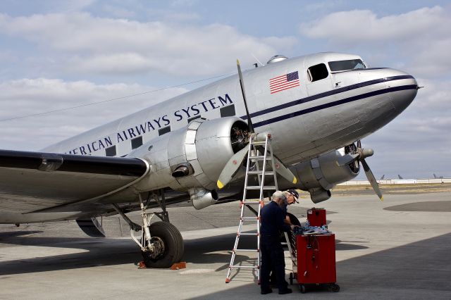 Douglas DC-3 (N877MG) - In a scene that could be right out of 1941 a mechanic and crew chief work diligently on their DC-3 at the Historic Flight Foundation at Paine Field in Everette, Washington (please view in "full" for highest image quality)