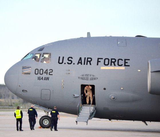 Boeing Globemaster III (97-0042) - USAF crew member is greeted by armed Canadian Border Services personnel as he lowers the stairs, upon arrival at Gander Airport.  This fuel tanker accompanied 3 F15s enroute to Europe.