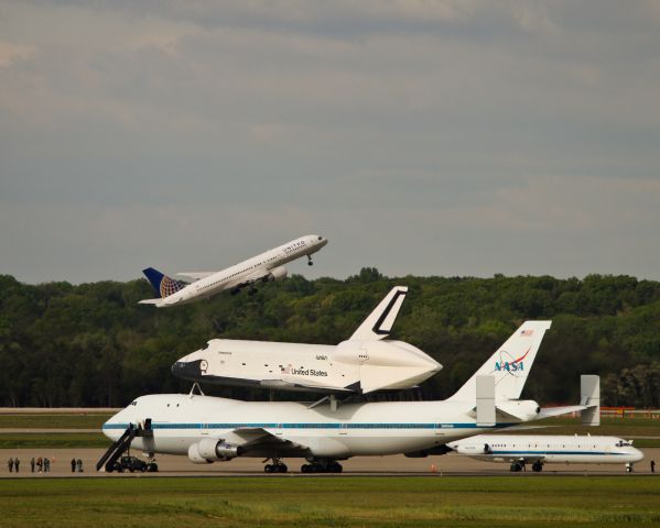 Boeing 757-200 (N572UA) - A United 757 climbing over a waiting NASA fleet, sitting on the W Apron at Dulles.