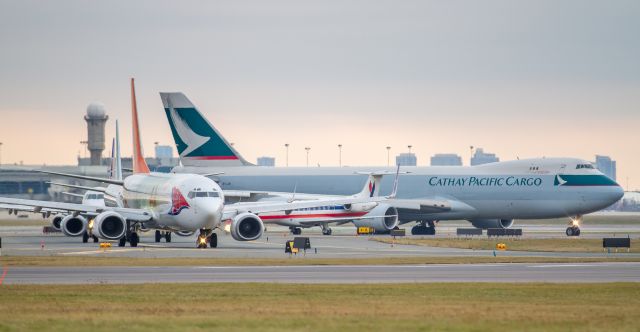 Boeing 737-800 (C-GRKB) - Behind the Sunwing 737 are Air Canada Embraer 175 C-FEIQ, United Express Embraer 170 N655RW, American Eagle Embraer 140LR N802AE, and Cathay Pacific Cargo Boeing 747-867F/SCD B-LJM, all lining up for a runway 23 departure at YYZ.