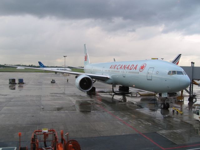 BOEING 777-300ER (C-FIVM) - Air Canada B777-333ER being readied, under stormy sky, for its daily trip to Paris.