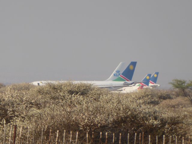 — — - Windhoek Hosea Kutako Intl Airport. From a hilltop beside B6, ca. 10 km west of the airport, someone has a great overview. Photo made with zoom 30.08.2017. The airliners seem to be parked in the bush. Between Air Namibia, a new guest appears - KLM A330. Since a few months, KLM flys from Amsterdam via Luanda to Windhoek. The 2 little ones in the background are Air Namibia A319-100.