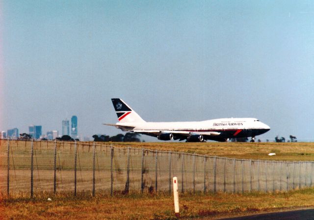 Boeing 747-200 (G-BNLB) - "City of Edinburgh" about to turn onto the main north south runway at Melbourne, late 1989.  Part of the city of Melbourne can be seen in the background through the heat haze. 