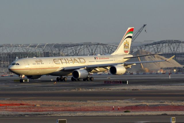 Airbus A340-600 (A6-EHA) - Early morning arrival with the new terminal under construction in the background