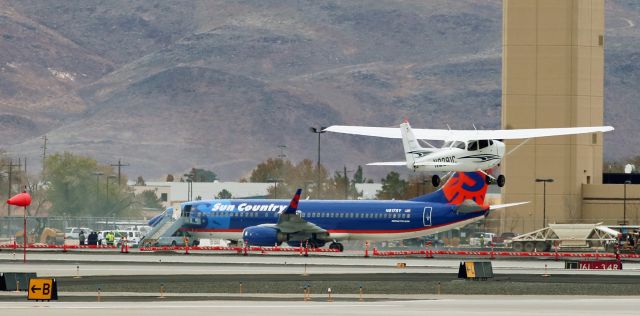 Cessna Skyhawk (N2291C) - A lot going on in this snap, taken yesterday, of Flying Start Aeros N2291C, a Cessna Skyhawk, as a student pilot lifts it away from runway 7 at KRNO.  br /This is the first gallery photo of N2291C.  I was going to post a full-side-view of it, but I decided I like everything shown in this shot.  First, this is the first time in my twenty years of spotting at RNO that Ive caught a runway 7 departure.  The wind very, very rarely comes blowing from out of the east, but as is quite obvious by the fully extended sock on the left side of this shot and all the blowing dirt in the background, yesterdays wind was really blasting from the east.  All that blowing dirt brought the construction taking place on taxiway Charlie to a halt.  And also in the background, SCXs N817SY is awaiting the arrival of the UNR (University of Nevada, Reno) football team to take the Wolfpack to its game against the Utah State Aggies in Logan, Utah.