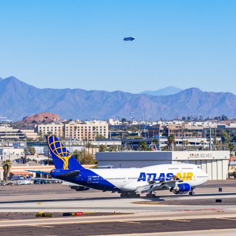 Boeing 747-400 (N482MC) - An Atlas Air 747-400 landing at PHX with a Goodyear blimp in the background on 2/10/23 during the Super Bowl rush. Taken with a Canon R7 and Canon EF 100-400 II L lens.