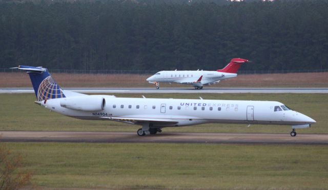 Embraer ERJ-145 (N14904) - With N12EC departing in the background via 34R