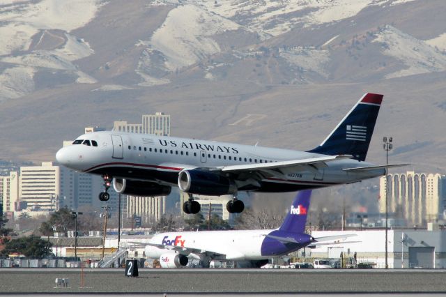 Airbus A319 (N827AW) - This first photo of N827AW in the FA photo gallery shows the AWE A319 just a few seconds from completing its approach to RTIAs runway 16R.  Downtown Reno and the white "R" on the lower slope of snow-covered Peavine Mountain can be seen in the background.