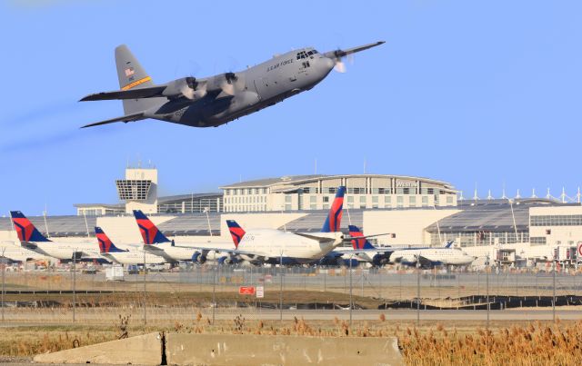 Lockheed C-130 Hercules — - This is a photoshopped image of a U.S Airforce Lockheed C-130 "Hercules" from 153rd ALG out of Cheyenne, Wyoming departing Detroit Metropolitan Airport on March 26th, 2016. I added the backdrop of the airport to distinugush where it was taking off from. My view of the runway was blocked from the original photo, so thats why I blended the two together!