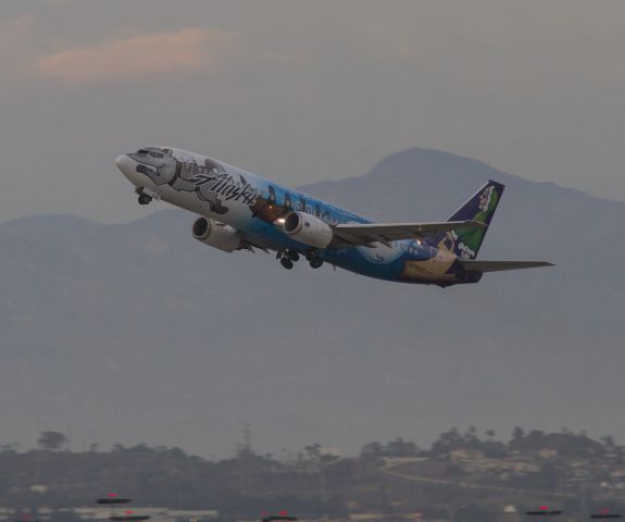 Boeing 737-700 (N705AS) - Sled dog makes an evening departure and heads west from Los Angeles (LAX) runway 25L.