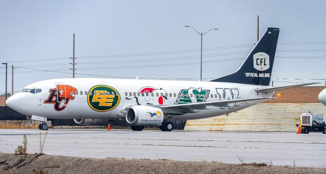 BOEING 737-300 (C-GCNO) - Canadian North 733 wearing the team logos of the Canadian Football league... 