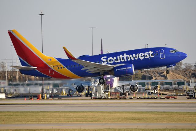 Boeing 737-700 (N7825A) - With a DC-10 photo bomb in the background. Departing 5-L at IND 11-09-19