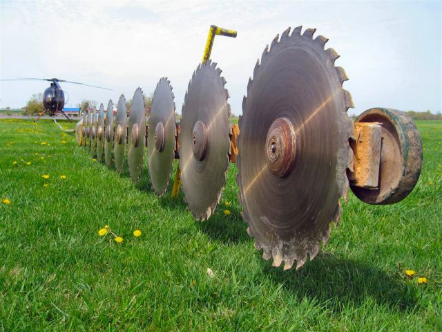 — — - This Rotax driven saw is hoisted aloft by the Hughes 500  and is used to trim trees on power and railroad right of way.Spectacular in use, noisy and tree limbs flying!