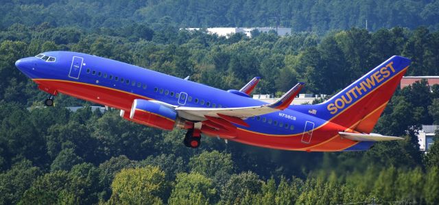 Boeing 737-700 (N738CB) - Blasting off from 23R headed to HOU, from on top of the RDU parking deck, 8/26/18.