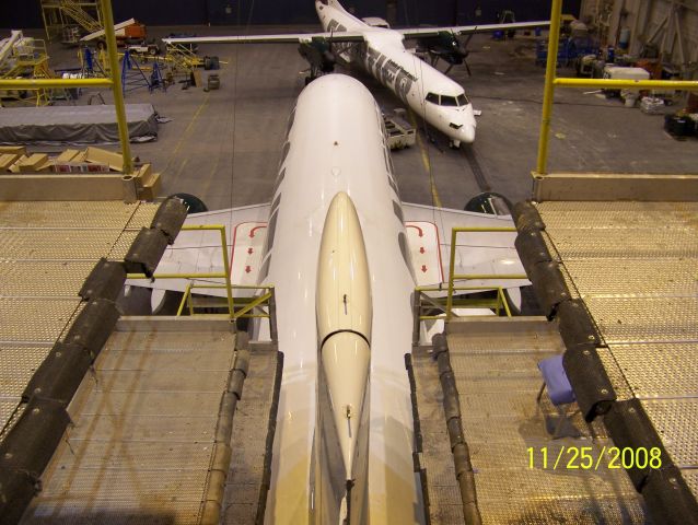 Airbus A319 (N932FR) - A unique view from a maintenance tail stand. Lynx Aviation Q400 in for maintenance in the background.