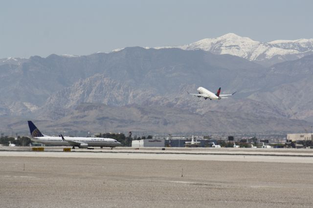 — — - Delta taking off runways 26R with Mt.Charlston in the background Klas