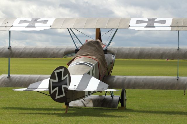 — — - WWI Tri-Plane on the flightline at Duxford Air Museum.