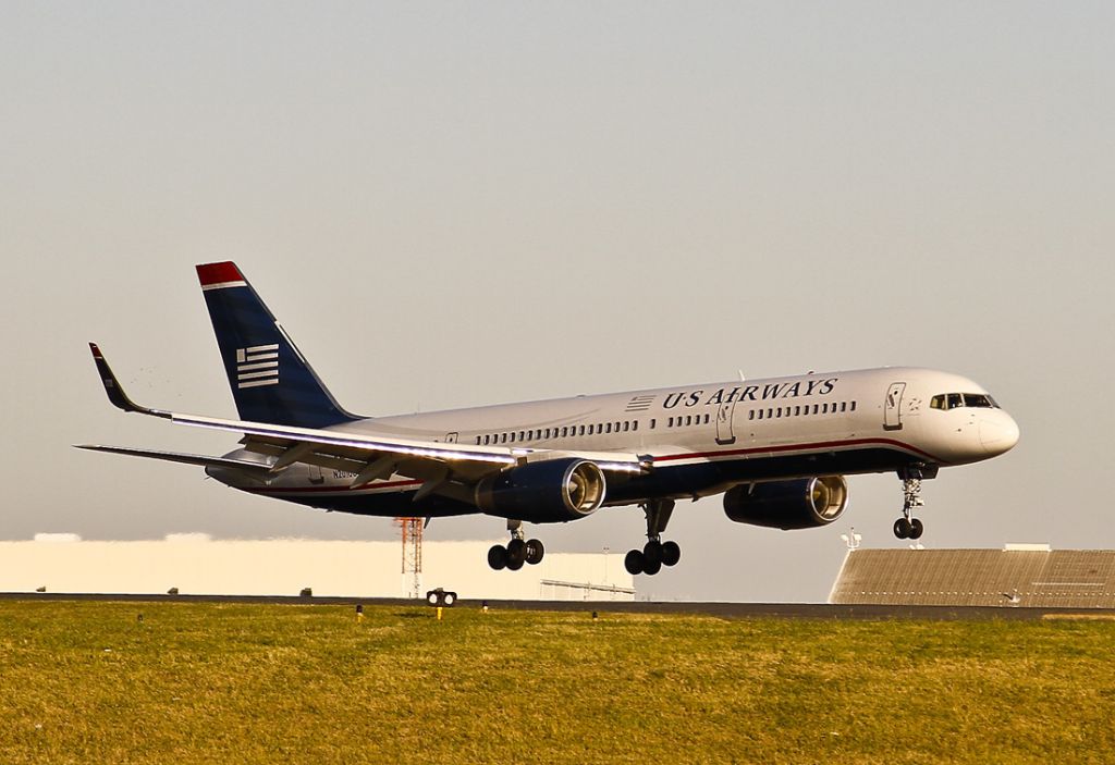 Boeing 757-200 (N201UU) - A late afternoon landing at Charlotte, North Carolina USA. A crosswind with a 5%25 down-sloping runway (runway 23) made for a gliding landing, touching down much closer to the photographer than usual. Landing into the setting sun helped to illuminate the 757s engine intakes.