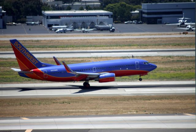 Boeing 737-700 (N919WN) - Shot from the South end of 7th Floor stair well of "The New Airport" Rental Car Garage .. San Jose Jet Center shows in background