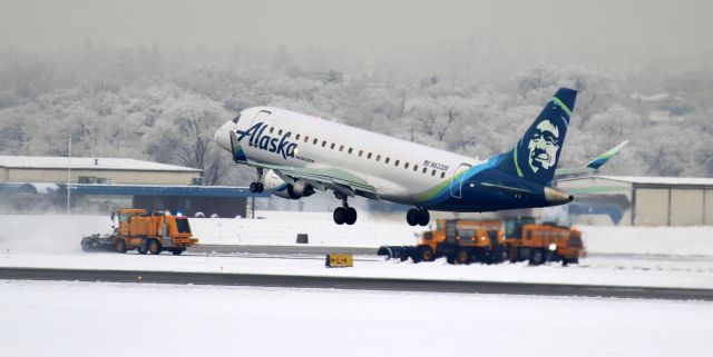 EMBRAER 175 (long wing) (N622QX) - Despite a coating of ice and snow on the runways, taxiways, and terminal aprons; as well as covering the trees and buildings on and near the airport; Reno Tahoe Airport Authority plow teams kept ILS Runway 16R-34L and taxiways Alpha, Lima, and Charlie open and useable, as evidenced by this snap of QXE's N622QX ... liberally covered with green deicing fluid on its wings, tail planes and tail ... on the climb from 16R as Plow One and Company scrape ice and a thin topping of snow from the intersection of taxiways Lima and Bravo.