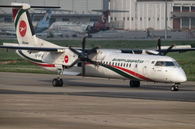 de Havilland Dash 8-400 (S2-AKF) - 24th April, 2025:  Flight BG 473 bound for Borishaal operated by "Sh'et Bolaka" is about to cross into rwy 14 for departure. Remains of United Airways BD's MD-80s can be seen in the background.