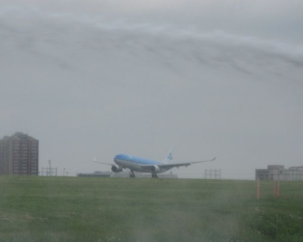 Airbus A330-300 (PH-AOB) - A airport firetruck was testing its hose during a airside tour of Toronto Pearson International Airport when a KLM A330 was touching landing on the 24R.