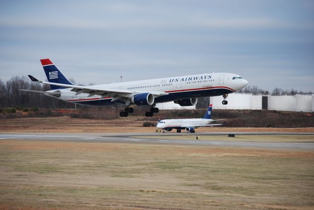 Airbus A330-300 (N270AY) - Landing on runway 18C at Charlotte Douglas International Airport while a US Airways Express E190 (N964UW) holds short - Jan. 2009