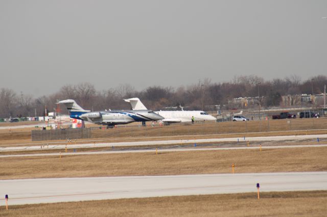 Bombardier Challenger 300 (N247FS) - Took this photo standing on top of the bleachers they have at the observation area at PWK that's why the photo isn't very clear.