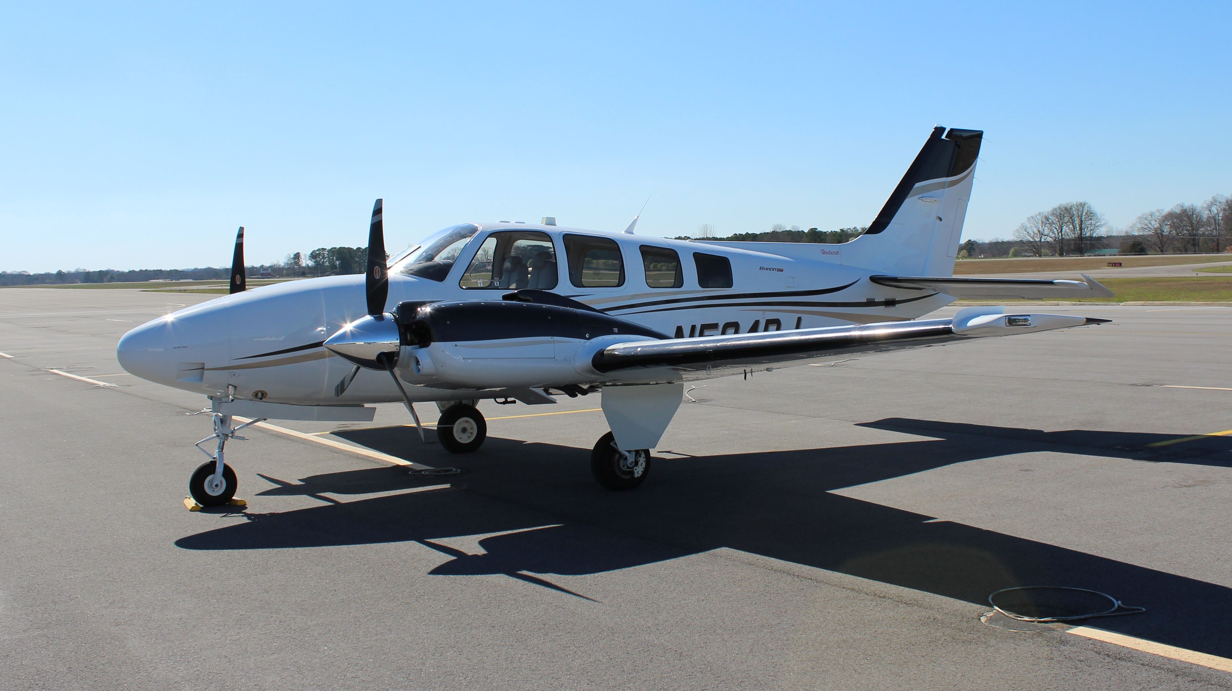 Beechcraft Baron (58) (N584RJ) - A Beechcraft G58 Baron on the ramp at Thomas J. Brumlik Field, Albertville Regional Airport, AL - March 10, 2017.  I realize this is the "shaded" side of the aircraft, but  I love the sun sparkle effects...