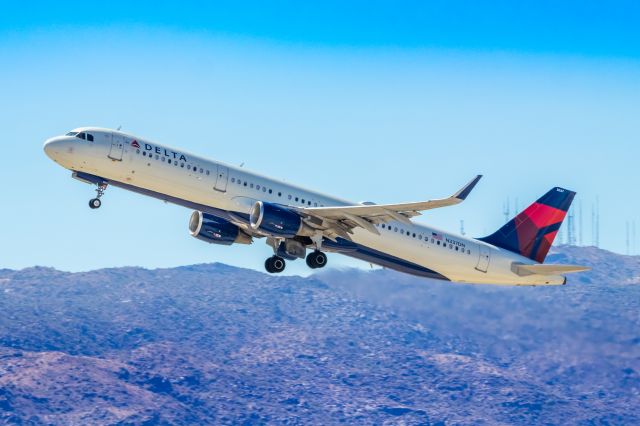 Airbus A321 (N377DN) - Delta Airlines A321 taking off from PHX on 10/9/22. Taken with a Canon 850D and Rokinon 135mm f/2 manual focus lens.