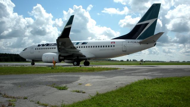 Boeing 737-700 (C-FCWJ) - Taxiing to Runway 25 2009:08:11. 14:36