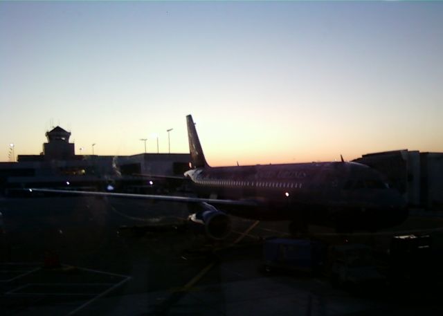 Airbus A320 (KCVG) - Waiting for my 7am flight back to Chicago. The camera phone did not capture how cool this looked with the sunrise and the morning condensation on the plane.