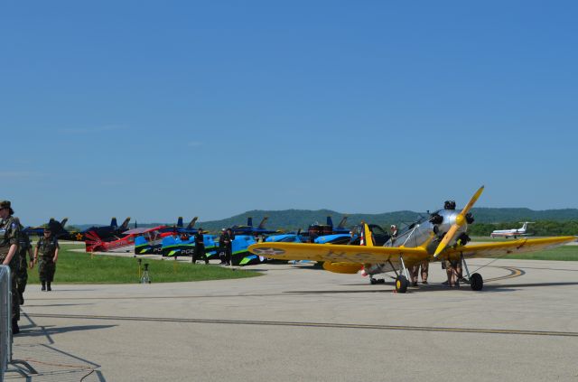 — — - Deke Slayton Airfest June 2014. The gang is all here! Most performers lined up. Ryan PT-22 in front followed by Vanguard Squadron, Bill Blanks Super Decathlon, Yak, and the Blue Angels in the distance. AA commuter rolling out in background as well.