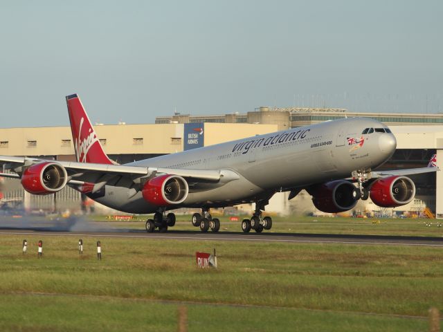 Airbus A340-600 — - VirginAtlantic A340-600, sporting the old livery of which they are many, touches down on runway 027R at LHR. Gradually they will be all painted in the ruby red, colour scheme that is flying on various aircraft in the fleet.