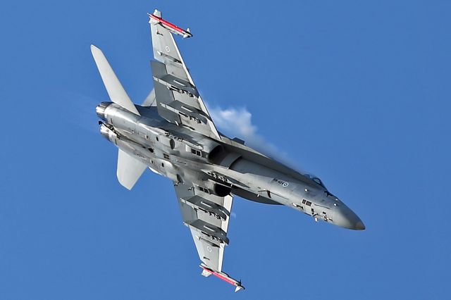 — — - Creating its own vapor during a high-g turn and getting the best light on its undersurfaces, this is a Finland AF FA-18A at RIAT 2015, Fairford, UK.
