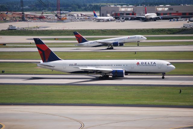 BOEING 767-300 (N153DL) - Arriving 26R while a company 757 departs runway 26L - 8/22/09