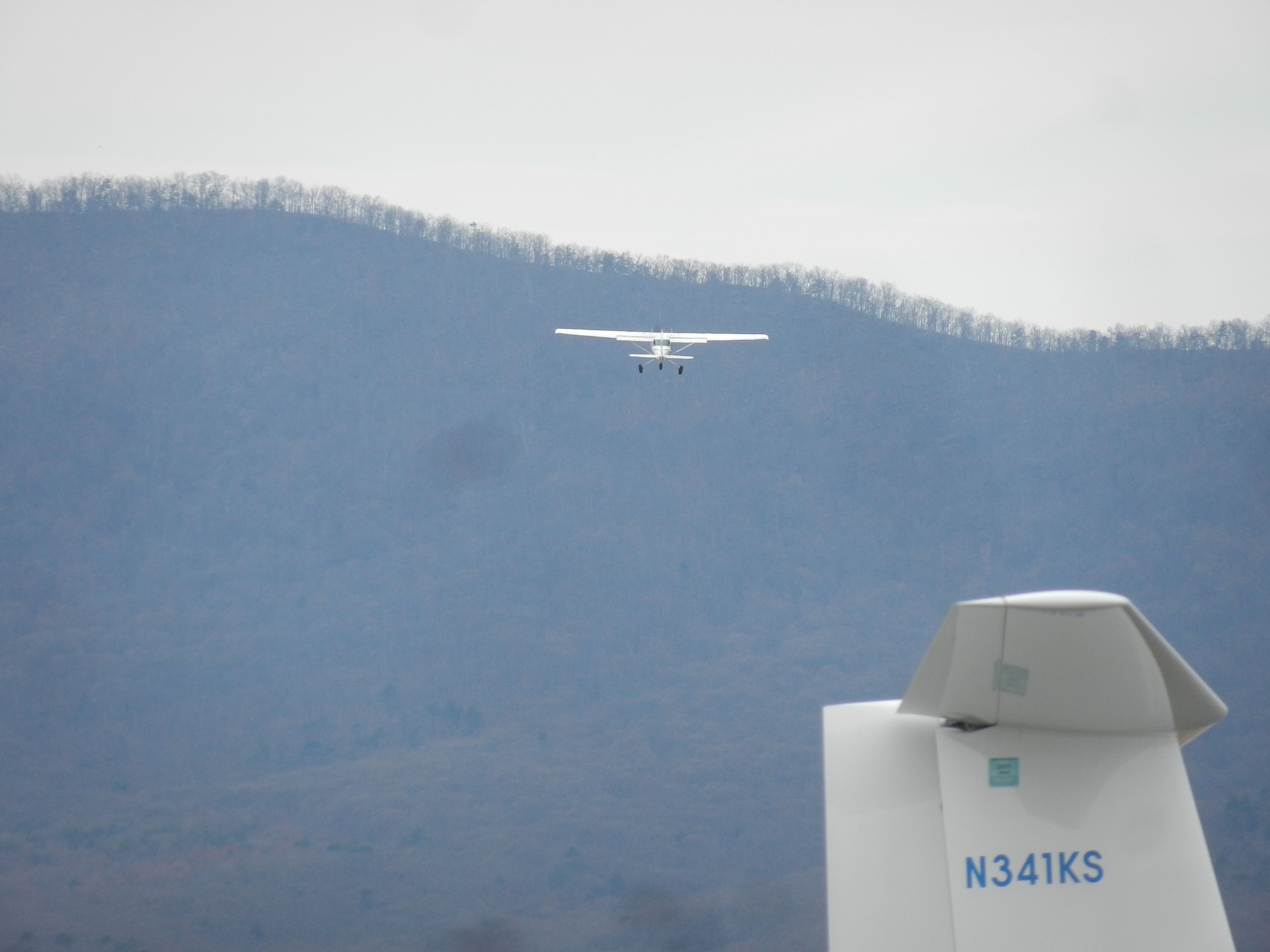 Beechcraft King Air 90 (N14CW) - N14CW, A Cessna C-172, Takes Off While The Distant Blue Mountains Are Seen In The Distance