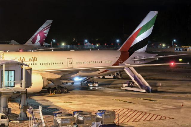 Boeing 777-200 (A6-EWG) - 24th June, 2018: Emirates (A6-EWG) and Qatar Airways (A7-BAZ) Boeing 777 seen parked at the gate in Phuket International Airport. This Thai resort town seems to be a popular destination for expat workers (and natives) of those middle eastern countries.