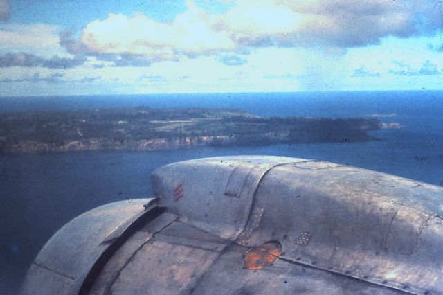 Douglas C-54 Skymaster (VH-EBN) - Dec 12 1971 and after many hours of non-pressurized flying our well-worn DC4 lined up for the (then) grass/coral runway on Norfolk Island (constructed by the US Navy in 1942).  The many, many patches attest to its numerous owners and flights since its delivery to the USAAF in 1944.  We were on our honeymoon and the "Norfolk Trader" served us well and didn't crash once while we were aboard.