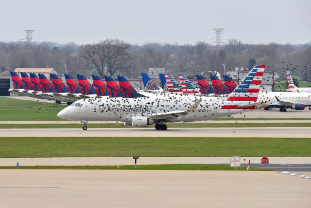 Embraer 175 (N445YX) - Getting escorted by a murmuration of Starlings to the end of the runway. RPA 175's parked on the Postal Ramp at KIND in the background on 04-06-20