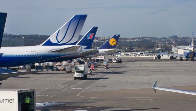 Boeing 747-400 (N119UA) - UA 747-422 N119UA next to a UA 777-200 still in the battleship grey livery and an LH 747-400 as UA 747-400 taxis out at SFO on Jan 14, 2010.