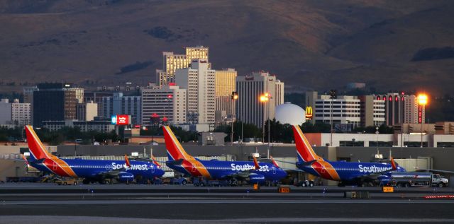 Boeing 737-800 (N8604K) - The sun has not quite come up over the Virginia Range mountains behind me but the sky is getting brighter (as reflected in the windows of downtown buildings) and Southwest's gates in Reno-Tahoe International's Concourse B are occupied with B737s getting ready to depart.