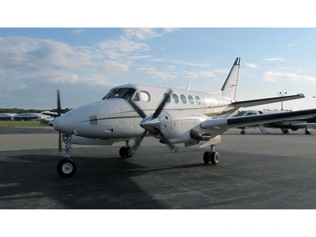 Beechcraft King Air 100 (N24EM) - A King Air 100 taxiing onto the ramp of the Million Air FBO at HPN.